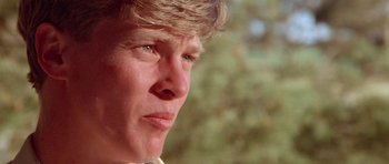 Movie still from “Gallipoli” (1981), directed by Peter Weir – A man's face with trees in the background; Close Up shot, Low angle