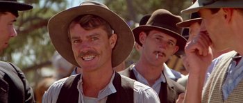 Movie still from “Gallipoli” (1981), directed by Peter Weir – A man with a hat and a mustache smoking a cigarette next to another man with a hat and a mustache; Close Up shot, Low angle