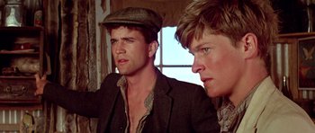 Movie still from “Gallipoli” (1981), directed by Peter Weir – A couple of men standing next to each other in front of a window; Close Up shot, Low angle