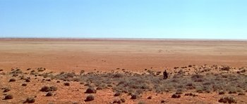 Movie still from “Gallipoli” (1981), directed by Peter Weir – A person standing in the middle of an empty desert; Extreme Wide shot, High angle