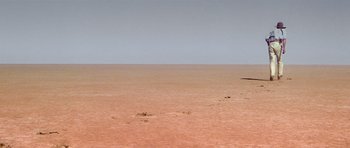 Movie still from “Gallipoli” (1981), directed by Peter Weir – An image of an empty beach with a boat in the distance; Extreme Wide shot, High angle