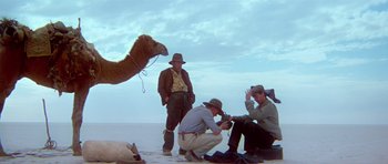 Movie still from “Gallipoli” (1981), directed by Peter Weir – A group of men standing next to each other on the beach; Wide shot, Low angle