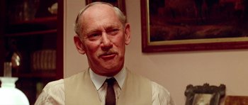 Movie still from “Gallipoli” (1981), directed by Peter Weir – An older man wearing a vest and a tie; Close Up shot, Over the shoulder angle