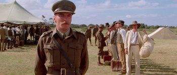 Movie still from “Gallipoli” (1981), directed by Peter Weir – A man in a military uniform standing in front of a group of men; Medium shot, Low angle