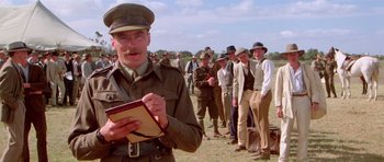 Movie still from “Gallipoli” (1981), directed by Peter Weir – A man in a military uniform standing in front of a group of men; Medium shot, Low angle