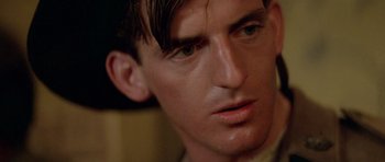 Movie still from “Gallipoli” (1981), directed by Peter Weir – A man's face with a serious look on his face; Close Up shot, Low angle