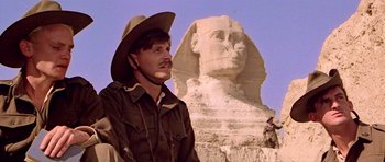 Movie still from “Gallipoli” (1981), directed by Peter Weir – A man wearing a cowboy hat standing in front of the sphinx; Close Up shot, Low angle