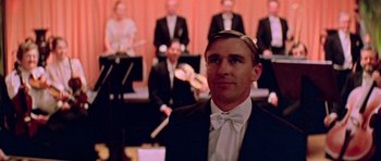 Movie still from “Gallipoli” (1981), directed by Peter Weir – A man in a suit and bow tie standing in front of a group of people; Close Up shot, Low angle