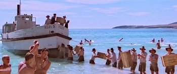 Movie still from “Gallipoli” (1981), directed by Peter Weir – A group of people in the water near a boat; Extreme Wide shot, High angle
