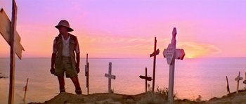 Movie still from “Gallipoli” (1981), directed by Peter Weir – A man walking on the beach near some crosses; Wide shot, Low angle