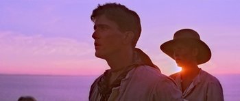 Movie still from “Gallipoli” (1981), directed by Peter Weir – A young man standing on top of a beach at sunset; Close Up shot, Low angle