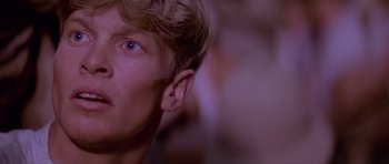 Movie still from “Gallipoli” (1981), directed by Peter Weir – A young man's face in a purple light; Close Up shot, Low angle