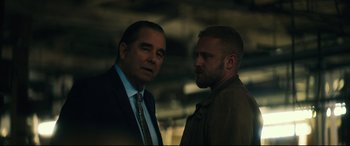Movie still from “Galveston” (2018), directed by Mélanie Laurent – Two men standing next to each other in a dark room; Close Up shot, Over the shoulder angle