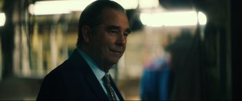 Movie still from “Galveston” (2018), directed by Mélanie Laurent – A person wearing a suit and tie; Close Up shot, Over the shoulder angle