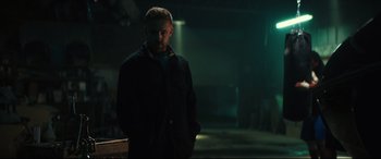 Movie still from “Galveston” (2018), directed by Mélanie Laurent – A man standing in a dark room with his hands in his pockets; Medium shot, Low angle