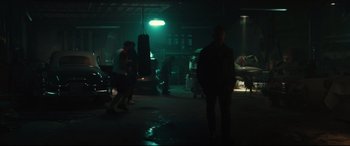 Movie still from “Galveston” (2018), directed by Mélanie Laurent – A group of people standing in a room with a punching bag; Wide shot, Low angle