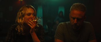 Movie still from “Galveston” (2018), directed by Mélanie Laurent – Two people are sitting in a room and one of them is smoking a cigarette; Medium shot, Over the shoulder angle