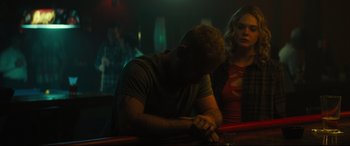Movie still from “Galveston” (2018), directed by Mélanie Laurent – A man sitting next to a woman in a dark room; Medium shot, Over the shoulder angle