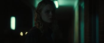 Movie still from “Galveston” (2018), directed by Mélanie Laurent – A woman with long blonde hair standing in a dark room; Close Up shot, Over the shoulder angle