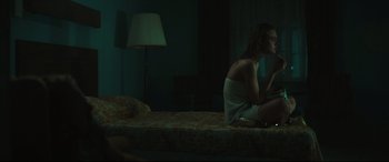 Movie still from “Galveston” (2018), directed by Mélanie Laurent – A woman sitting on top of a bed at night; Medium shot, Over the shoulder angle