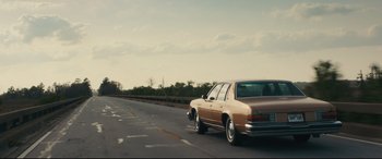 Movie still from “Galveston” (2018), directed by Mélanie Laurent – A car driving down the road on a cloudy day; Extreme Wide shot, Low angle