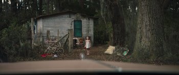 Movie still from “Galveston” (2018), directed by Mélanie Laurent – A little girl standing in front of an old house; Extreme Wide shot, High angle