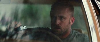 Movie still from “Galveston” (2018), directed by Mélanie Laurent – A person with a beard looking at the camera; Close Up shot, Over the shoulder angle