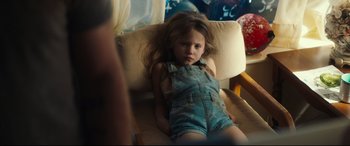 Movie still from “Galveston” (2018), directed by Mélanie Laurent – A little girl sitting in a chair with her head down; Medium shot, High angle