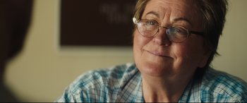 Movie still from “Galveston” (2018), directed by Mélanie Laurent – An older woman wearing glasses and a plaid shirt; Close Up shot, Over the shoulder angle