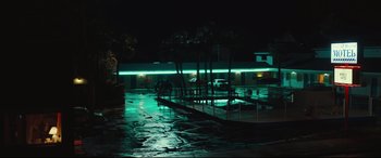 Movie still from “Galveston” (2018), directed by Mélanie Laurent – A night scene of an empty parking lot with neon lights; Extreme Wide shot, Low angle