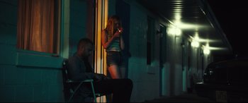 Movie still from “Galveston” (2018), directed by Mélanie Laurent – A woman standing next to a man on a phone; Medium shot, Low angle