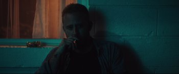 Movie still from “Galveston” (2018), directed by Mélanie Laurent – A man smoking a cigarette while sitting in a room; Close Up shot, Over the shoulder angle
