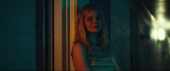 Movie still from “Galveston” (2018), directed by Mélanie Laurent – A young woman standing next to a window; Close Up shot, Over the shoulder angle
