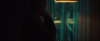 Movie still from “Galveston” (2018), directed by Mélanie Laurent – A man talking on a cell phone next to a woman in front of a window; Medium shot, Over the shoulder angle