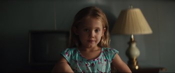 Movie still from “Galveston” (2018), directed by Mélanie Laurent – A little girl with long blonde hair wearing a blue shirt; Close Up shot, Over the shoulder angle