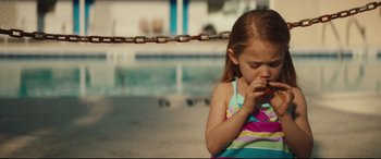 Movie still from “Galveston” (2018), directed by Mélanie Laurent – A little girl eating a piece of fruit; Close Up shot, High angle