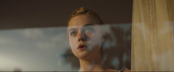 Movie still from “Galveston” (2018), directed by Mélanie Laurent – A young woman looking out a window at the camera; Close Up shot, Low angle