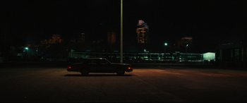 Movie still from “Galveston” (2018), directed by Mélanie Laurent – A car is parked in a parking lot at night; Extreme Wide shot, Low angle