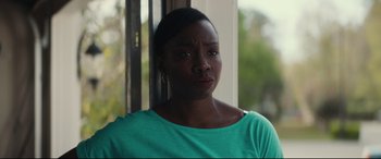 Movie still from “Galveston” (2018), directed by Mélanie Laurent – A woman in a green shirt is looking out of a window; Close Up shot, Over the shoulder angle