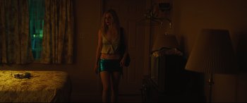 Movie still from “Galveston” (2018), directed by Mélanie Laurent – A woman standing in a dark room holding a bag; Medium shot, Low angle