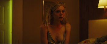 Movie still from “Galveston” (2018), directed by Mélanie Laurent – A young blonde woman in a silver dress looking at the camera; Close Up shot, Over the shoulder angle