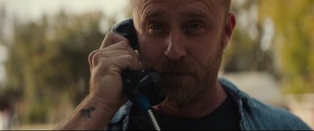 Movie still from “Galveston” (2018), directed by Mélanie Laurent – A man with a beard is talking on a phone; Close Up shot, Low angle