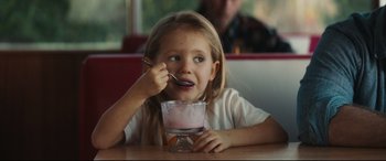 Movie still from “Galveston” (2018), directed by Mélanie Laurent – A little girl sitting in front of a bowl of ice cream; Medium shot, Over the shoulder angle