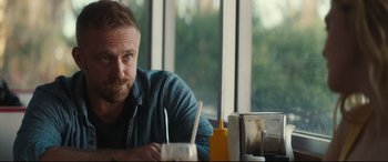 Movie still from “Galveston” (2018), directed by Mélanie Laurent – A person sitting at a table; Close Up shot, Over the shoulder angle