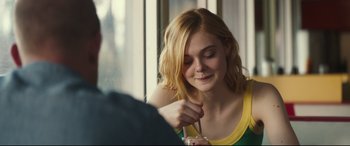 Movie still from “Galveston” (2018), directed by Mélanie Laurent – A woman sitting at a table with a drink in front of her face; Close Up shot, Over the shoulder angle