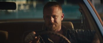 Movie still from “Galveston” (2018), directed by Mélanie Laurent – A man sitting in the driver's seat of a car; Close Up shot, Over the shoulder angle