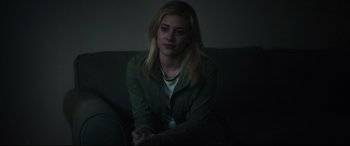 Movie still from “Galveston” (2018), directed by Mélanie Laurent – A woman sitting on a couch in a dark room; Medium shot, Over the shoulder angle