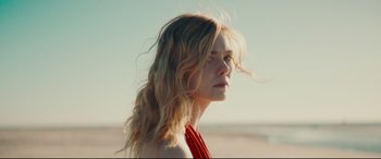 Movie still from “Galveston” (2018), directed by Mélanie Laurent – A woman with long blonde hair wearing a red top; Close Up shot, Low angle