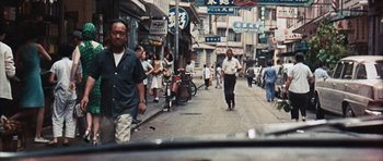 Movie still from “Gambit” (1966), directed by Ronald Neame – A group of people walking down a street; Wide shot, High angle