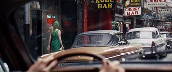 Movie still from “Gambit” (1966), directed by Ronald Neame – Two women are walking down the street in front of a car; Wide shot, Over the shoulder angle